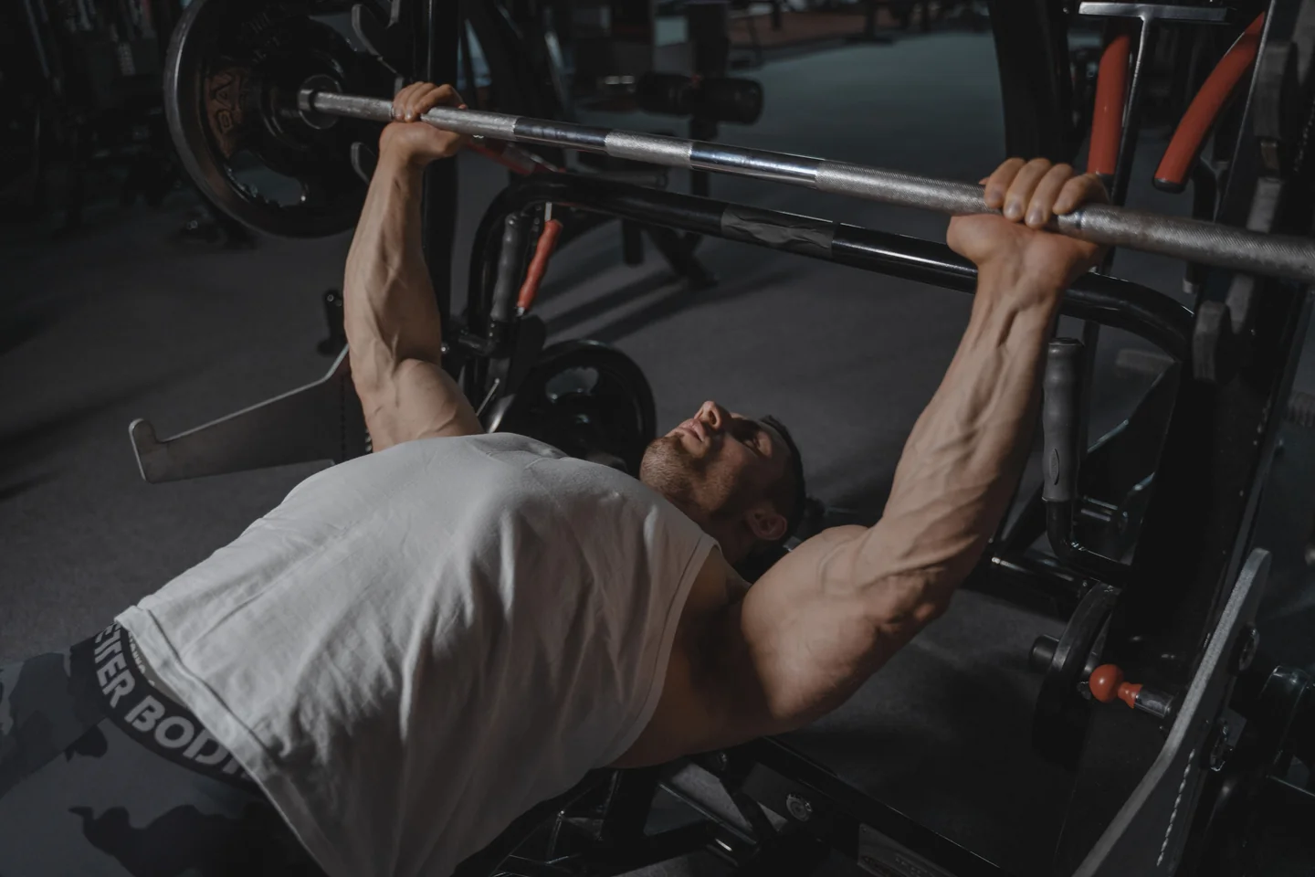 A lifter pressing a heavy barbell on a bench press