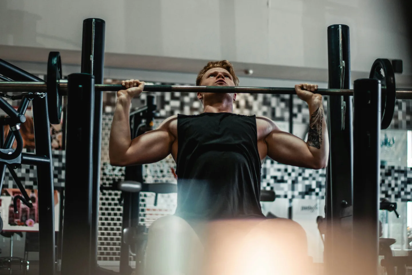 A lifter straining through the last reps of an overhead press